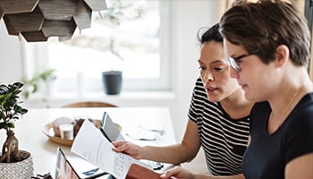 Two people working on paperwork together