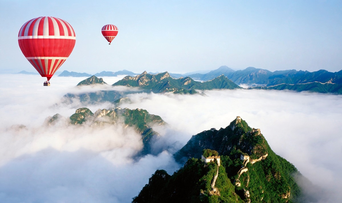 Hot air balloon flying over mountains 