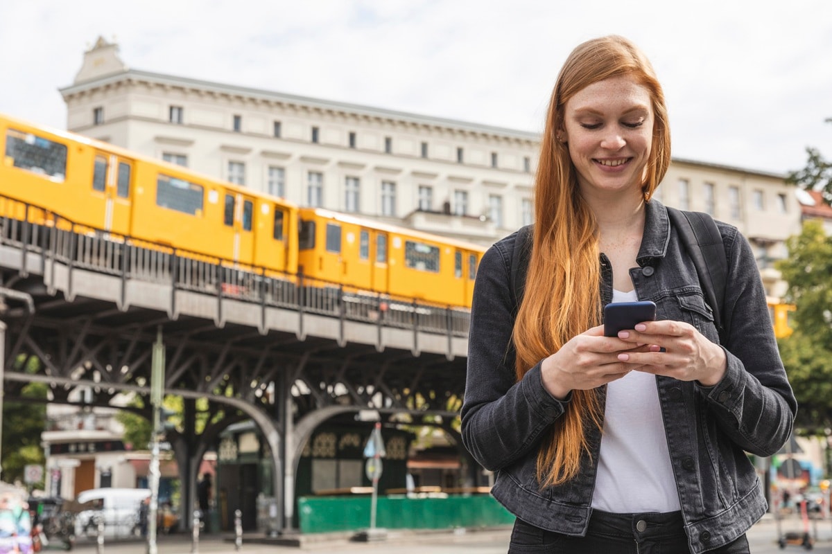 Lady with red hair standing in front of yellow train