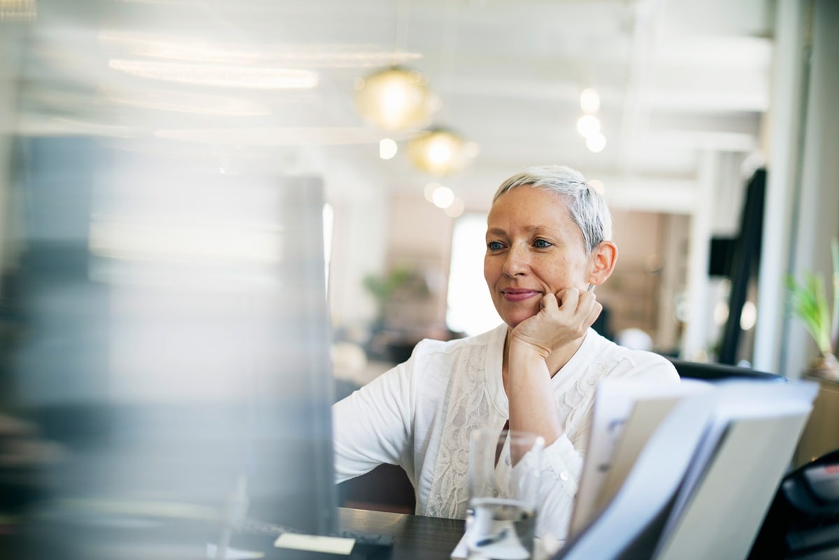 Lady wtih grey hair sitting at desk
