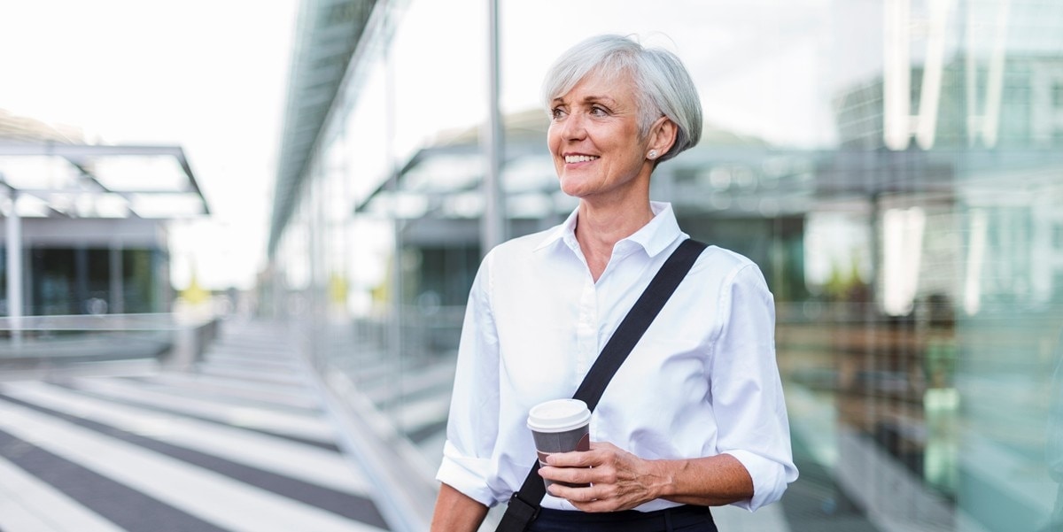 woman walking outside, coffee cup in hand