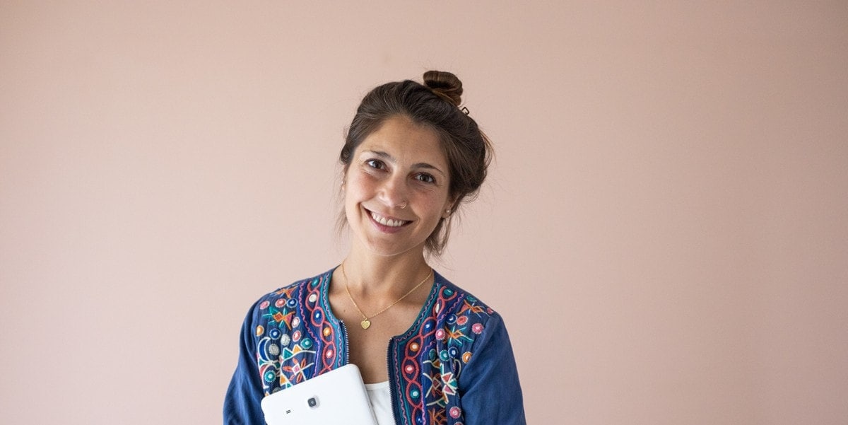 woman smiling, holding a tablet