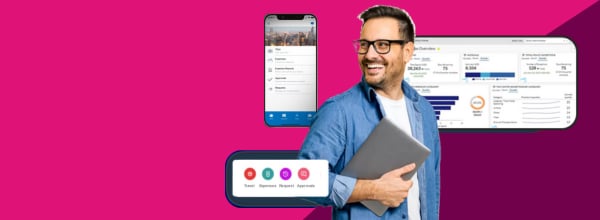 smiling male with glasses surrounded by digital devices